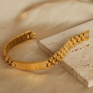 Gold-plated stainless steel president link bracelet with rectangular ID plate on marble