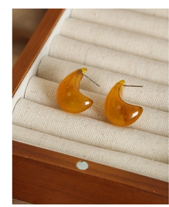 Detailed shot of amber resin drop earrings with marble texture in a wooden jewelry box