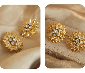 Macro detail of vintage gold sunflower earrings with cubic zirconia and petal texture