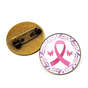 Detailed view of pink ribbon breast cancer awareness brooch with bronze metal back pin