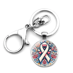 Pink ribbon breast cancer awareness keychain with floral glass pendant on white background