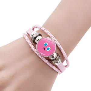 Dettaglio del bracciale a strati rosa con ciondolo emoji cartoon indossato al polso