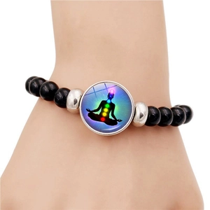 Yoga meditation chakra bracelet with black beads and a glowing seven-color soul pendant