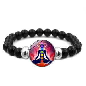 Close-up of black beaded energy bracelet with colorful seven chakra meditation pendant