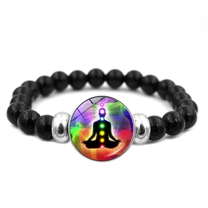 Close-up of meditation bead bracelet featuring a zen figure silhouette and chakra dots
