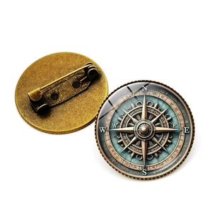 Vues détaillées avant et arrière d'une broche boussole vintage avec finition bronze antique