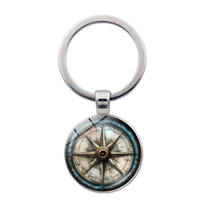 Macro detail of vintage compass pendant with antique map design on a silver keychain