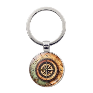 Close-up of vintage nautical compass keychain with polished silver metal and glass dome