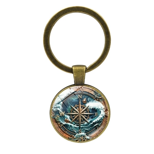 Macro detail of antique bronze nautical keychain featuring sailboat and compass art