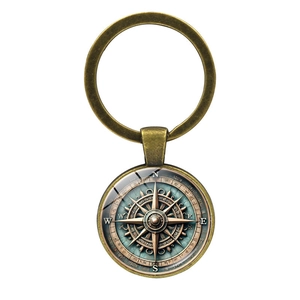 Close-up of vintage bronze nautical compass keychain with glass cabochon detail