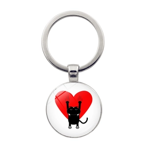 Detailed view of silver metal keychain with black cat and red heart glass pendant