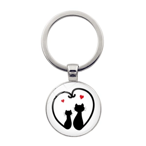 Detailed view of silver cat keychain with heart and black kittens under glass dome