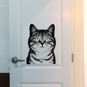 Detailed view of creative tabby cat wall sticker with artistic black outlines on a white door