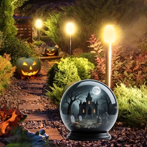 Halloween crystal ball yard stake featuring a miniature castle and tombstone landscape