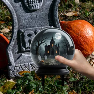 Détail macro du piquet de jardin boule de cristal d'Halloween avec maison hantée et château