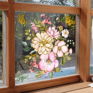 Detailansicht von Blumen- und Schmetterlingsaufklebern mit Goldrand auf einer Glasscheibe