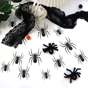 Detail of 3D Halloween spiders with green and red gem eyes and black silhouette cutouts