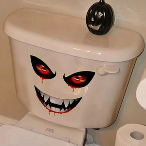 Dettaglio macro di occhi di mostro e zanne adesive luminose su serbatoio del WC