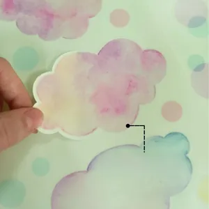 Close-up of peeling a watercolor cloud sticker showing glow-in-the-dark material and texture