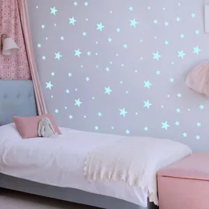 Luminous star wall stickers in various sizes glowing on a blue bedroom wall for kids room