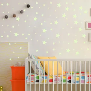 Detailed view of luminous glow-in-the-dark star stickers applied to a white nursery wall