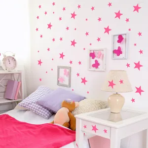 Pink star wall decals applied on walls, bedside tables and lamps for a warm nursery decor