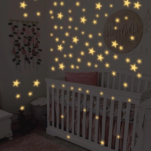 Luminous star wall stickers glowing in a dark baby nursery room with star patterns