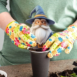 Close-up of cute garden gnome stakes and colorful floral printed garden gloves for outdoors