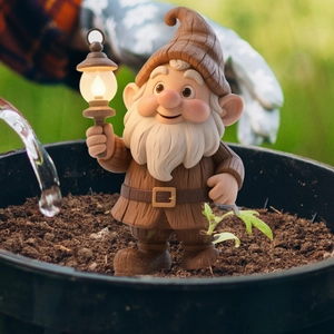 Detailed garden gnome statue with LED lantern ornament in a potted plant setting