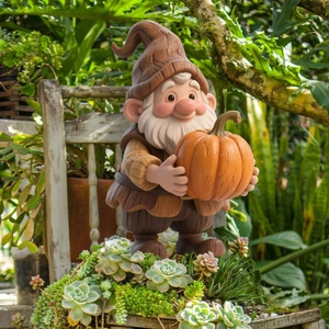 Garden gnome statue holding an orange pumpkin with wood-like texture for yard decor