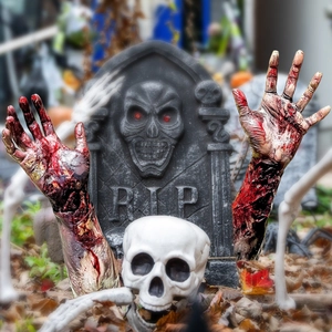 Close-up of Halloween RIP tombstone and bloody zombie hands for garden yard decor