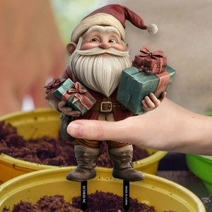 Detail showing Santa Claus PVC garden stake with gift boxes being placed in a flower pot
