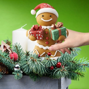 Close-up of Christmas gingerbread man figurine in decorative pine needle wooden gift box