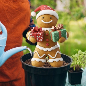 Detailed view of gingerbread man garden stake in a flower pot with festive holiday decor