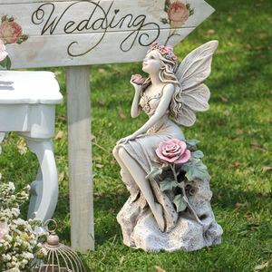 Garden fairy statue with pink roses and stone texture for outdoor patio decor