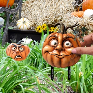 Close-up of vibrant orange pumpkin garden stakes with expressive faces for Halloween