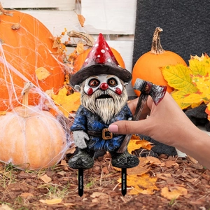 Detail of Halloween gnome garden stake with bloody axe and horror clown face paint