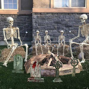 Halloween garden decor set with realistic life-size skeletons and aged tombstones on lawn