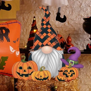 Halloween tuinkabouter en pompoen decoraties op hooi met een rustieke bakstenen muur