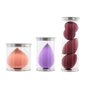 Set bunter Make-up-Schwämme in transparenten zylindrischen Behältern mit Metallbechern