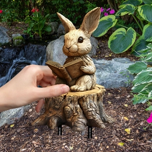 Garden rabbit figurine reading on stump with wood texture for outdoor yard decor
