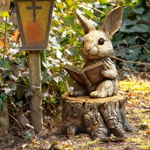 Detailed view of a realistic resin rabbit statue reading on a stump in a garden setting
