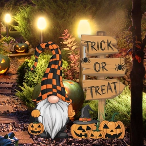Halloween tuinkabouter met pompoenstekers en Trick or Treat-bord in de nachttuin