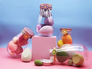 Close-up of colorful makeup sponges in a clear 500ml storage bottle with daisy cap