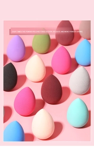 Macro view of multi-color teardrop makeup sponges in a neat array on pink background