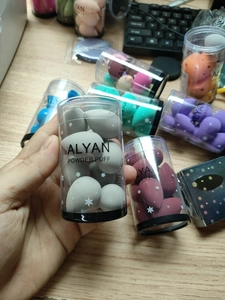 Macro view of ALYAN mini makeup sponge set featuring multi-colored puffs in a clear cylinder