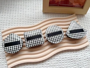 Close-up of houndstooth makeup puff set with round, square, triangle and teardrop shapes