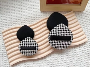 Macro view of four-piece marshmallow makeup sponges with houndstooth patterns on a tray