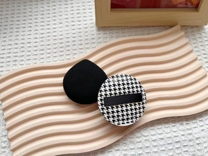 Detail of teardrop and houndstooth cushion puffs on a textured minimalist stand