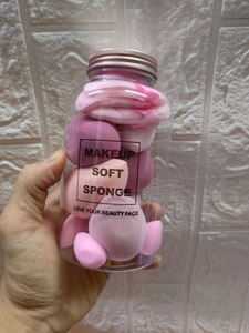 Detailed macro view of 14-piece makeup sponge set in a clear jar with a rose gold lid